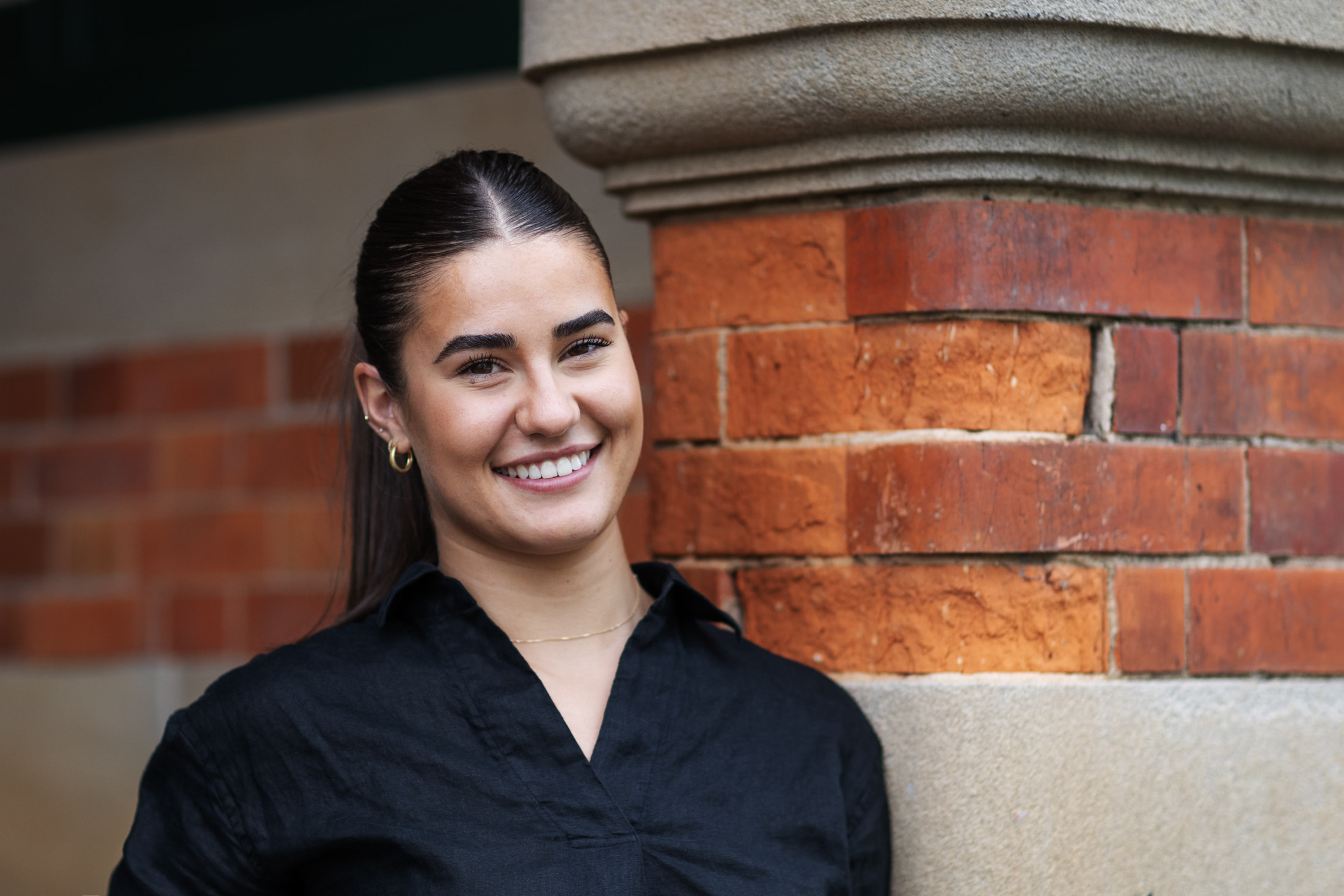 student standing in front of brick wall